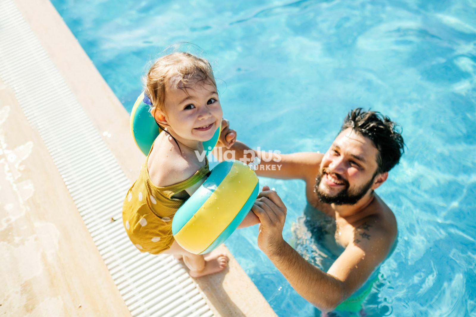 a father having fun in the pool with his daughter